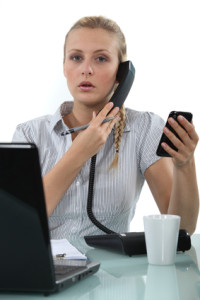 Office worker with two phones